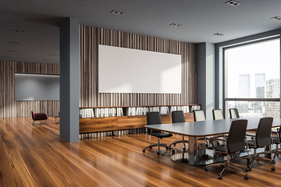 Executive corporate boardroom with long conference table and integrated display technology for enterprise collaboration
